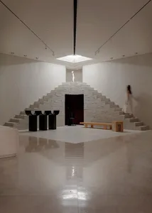 A minimalist interior space featuring concrete walls and steps.