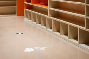 Floor space showcasing minimalist shoe-changing room with wooden shelves
