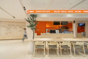 Modern cafe space with clean lines, wooden tables, and a large table with chairs.