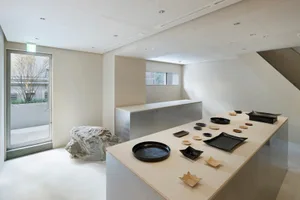 A modern ceramic display featuring various black trays and dishes on a white countertop.