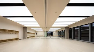 Modern dance studio with wooden floor, glass curtains, and large windows.