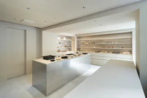 Modern display case featuring white glass elements and various ceramic products.