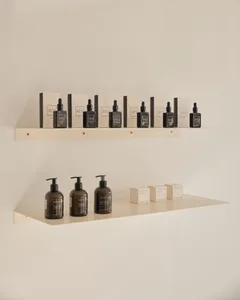 Organic beauty products displayed on minimalist shelves in an interior setting.