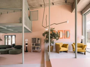 A modern office lobby with concrete walls and pastel-colored accents. Features include a concrete chandelier, pastel-colored 
