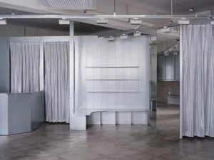 Minimalist interior of a retail shop featuring metal, glass, and mirrored surfaces.