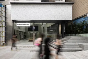 A modern storefront with a glass facade in an urban setting.