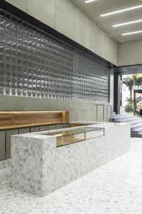 A modern restaurant counter with a marble facade and glass display case.