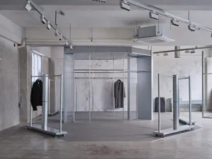 Modern retail display featuring metal and glass structures for clothing presentation.