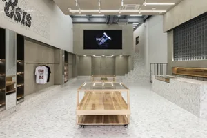 現代零售店面，展示木質、混凝土與大理石桌，背景有數位顯示器。