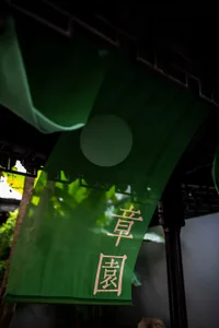 A green banner with Chinese characters hanging from a wooden beam