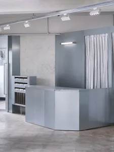 A minimalist industrial-style lobby with metallic elements and concrete flooring.