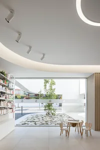 A modern commercial interior featuring a white concrete floor and minimalist design elements.