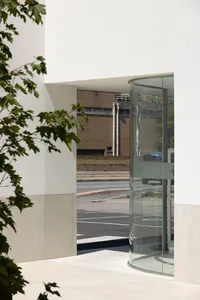 A modern entrance with a glass door, featuring sleek, clean lines and a clean, minimalist design.