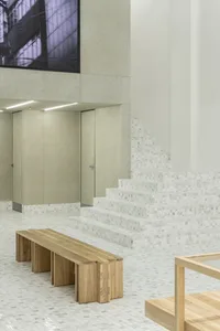Industrial-style interior with concrete walls, marble stairs, and wooden bench and table
