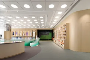 Modern retail store interior with light wood materials and functional display spaces.