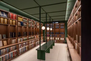 一間光線充足的現代圖書館，配有木質書架與混凝土地板。