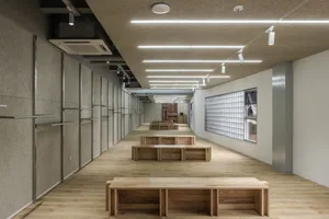 Modern office space featuring wooden benches and concrete walls