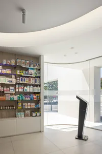 現代藥局內的玻璃展示架擺滿各式藥品，並設有立式服務螢幕。