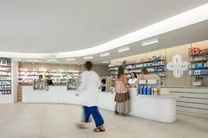 A modern pharmacy with a wooden counter and concrete walls.