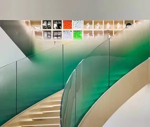 Modern retail space featuring a glass staircase with green accents.