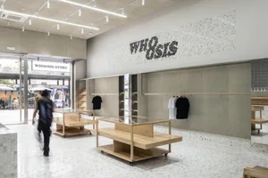 A retail shop with wooden shelves and concrete walls.