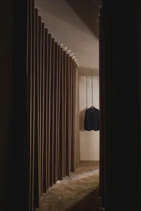 A minimalist fashion shop with a single clothes hanger displaying a suit.