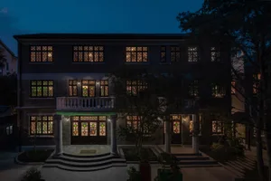 A modern bookstore exterior made of brick and glass, featuring illuminated stained glass windows.