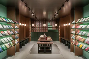 A modern bookstore with wooden shelves and green wall panels