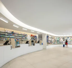 A sleek, contemporary pharmacy interior featuring wooden counters, LED lighting, and well-stocked shelves.
