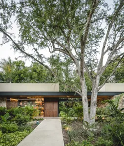 A modern residential exterior featuring stone, wood, and glass.