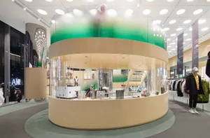 A round retail display with wooden materials inside a modern retail store.