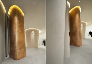 A modern retail storefront featuring a wall of curved wall-cladding adorned with concrete material and warm lighting to creat