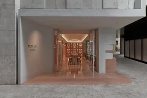 A minimalist retail storefront with concrete walls and lighting.