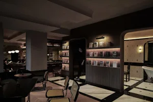 Interior design of a modern bar featuring concrete walls and flooring.