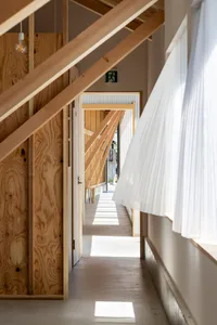 A modern corridor with wooden beams, concrete flooring, and metal accents