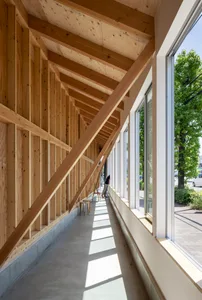 A modern industrial construction space featuring wooden beams and concrete floor.