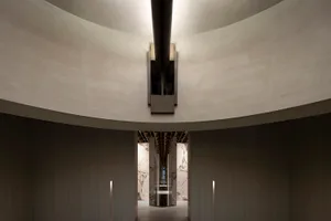 Modern interior featuring concrete columns and a circular ceiling.
