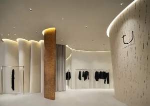 A clothing store with modern interior design features concrete surfaces.