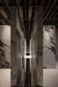 A modern sculpture made of marble and concrete materials, featuring a geometric design.