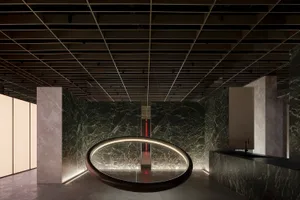 A modern public space featuring marble walls and lighting.