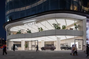 Modern retail storefront featuring a glass and metal facade with stone accents.