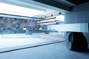 A minimalist retail storefront with glass walls and a polished concrete floor.