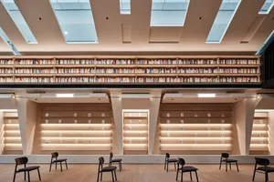 Library interior with wooden bookshelves filled with books.