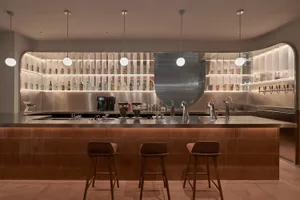 Minimalist bar with concrete finishes and modern lighting fixtures.