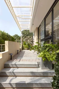 Modern entrance with granite steps, glass panels, and concrete planters.