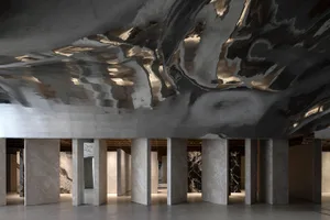 Modern interior space featuring integrated concrete columns and textured ceiling