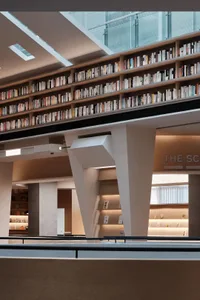 現代圖書館室內空間，金屬框架懸浮書架展示各式書籍。