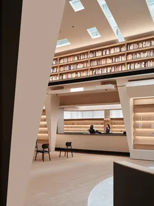 現代圖書館室內視圖，擁有高聳書架擺滿書籍、接待桌，以及簡約設計