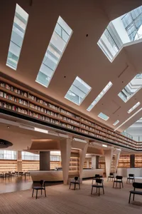 寬敞的現代圖書館，木質地板、玻璃牆面與混凝土柱。
