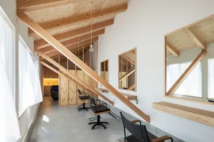 Minimalist commercial interior featuring wooden beams and chairs.